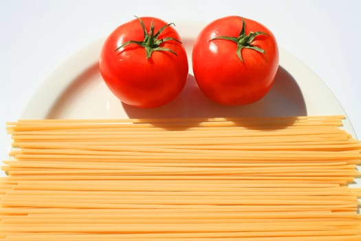 Close up of a pasta and tomatos on a plate.
