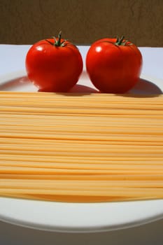 Close up of a pasta and tomatos on a plate.
