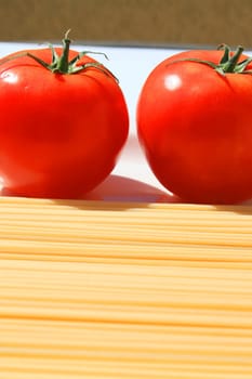 Close up of a pasta and tomatos on a plate.
