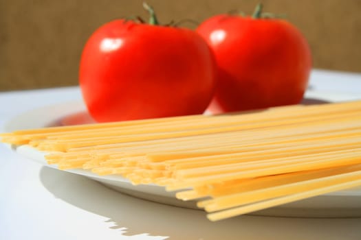 Close up of a pasta and tomatos on a plate.
