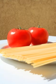 Close up of a pasta and tomatos on a plate.
