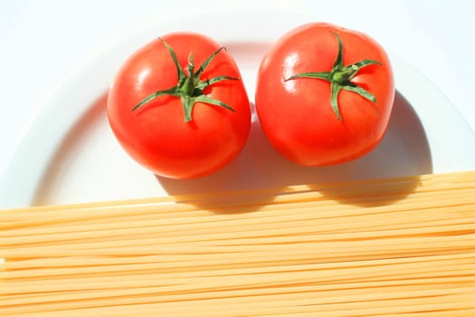 Close up of a pasta and tomatos on a plate.
