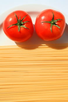 Close up of a pasta and tomatos on a plate.
