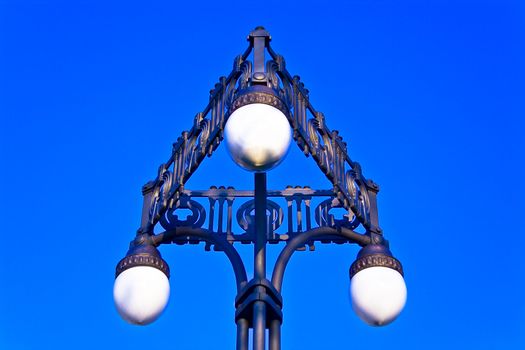 Old street lamppost on blue sky