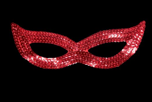 Masquerade red mask isolated on black background.