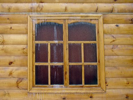 Wooden wall of the house covered with ice