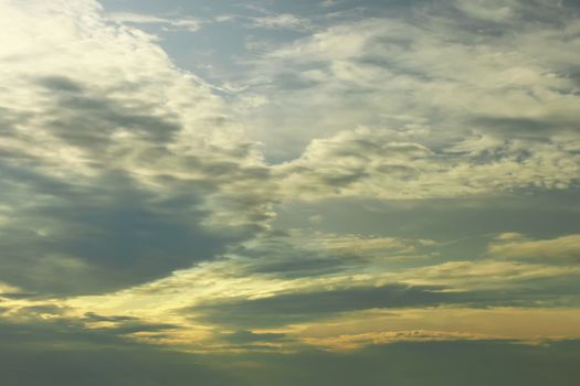 Dramatic cloudscape at sunset time. Sunlight passes through the dense clouds