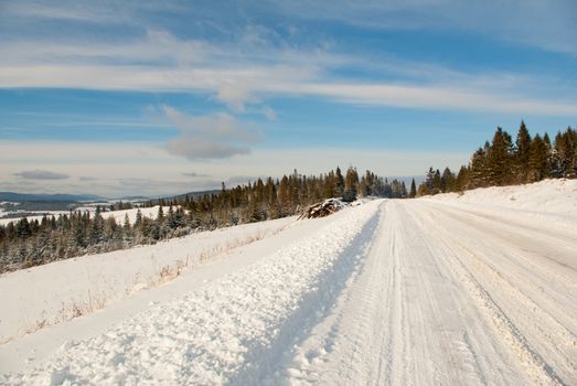 snow mountain winter road on fir tree forest and blue sky background