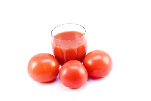 Tomatoes and a glass of tomato juice on white background