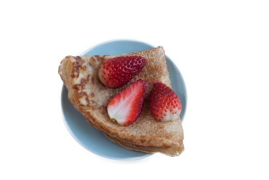 Pancake with strawberries and jam on a blue saucer.