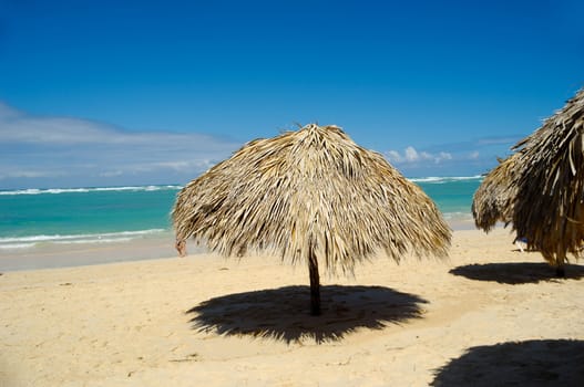 Parasol made out of palm leafs on beach.