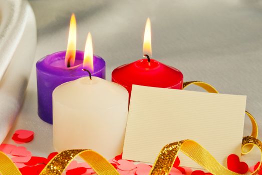 Three burning candles over light background