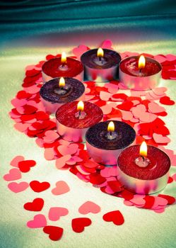 Burning candles heart shaped on a light background with shallow depth of field