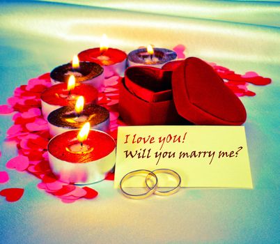 Blank card and two rings with heart shaped box and candles