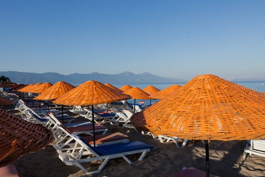 Beach loungers and umbrellas on the sea.