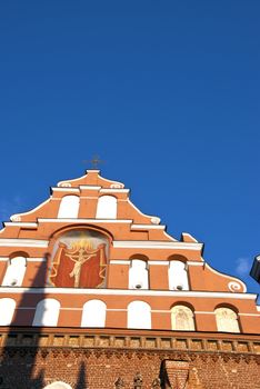 Church tower. Jesus crucified in ark. Religious picture. Blue sky.