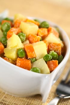 Vegetarian Russian Salad, also called Salad Olivier, made of potato, carrot and peas mixed with mayonnaise (Selective Focus, Focus one third into the bowl) 