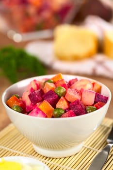 Russian beetroot salad made of beetroot, potato, carrot, pea and a mayonnaise dressing (Selective Focus, Focus on the top of the vegetables in the middle) 