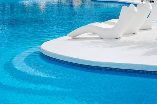 Sun-beds near a swimming pool to relax