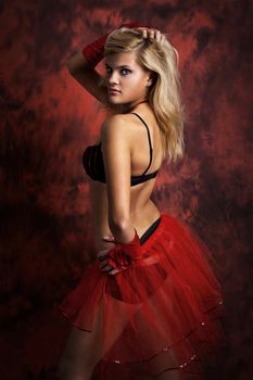Image of a sexual blonde girl  on dark red background posing for camera