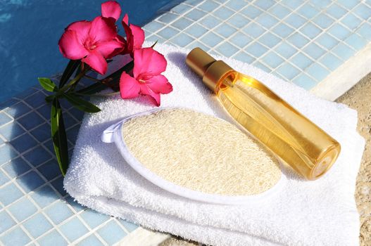 massage oil, shellfish and white towel beside a pool