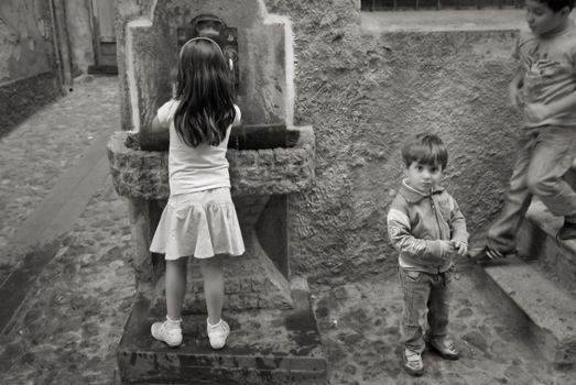 ACTIVE CHILDREN IN ALLEY, LONGOBUCCO, ITALY, SEPTEMBER 15 - 2011:  Kids in a narrow alley in the mountain village Longobucco, Calabria - Italy. Monochrome image - soft focus.