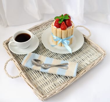 Dessert souffle with biscuit and fresh strawberries on a tray with a cup of coffee