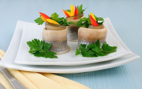 Rolls of herring fillets with pickled cucumber and pepper and parsley