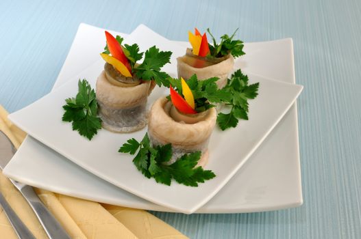 Rolls of herring fillets with pickled cucumber and pepper