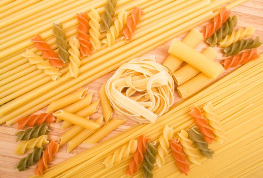 Different kinds of italian pasta on the wooden background