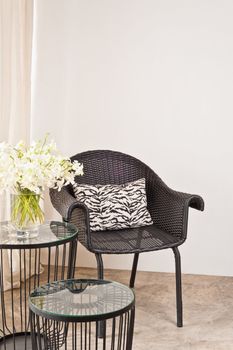 Brown rattan Chair in interior setting in front of a white wall