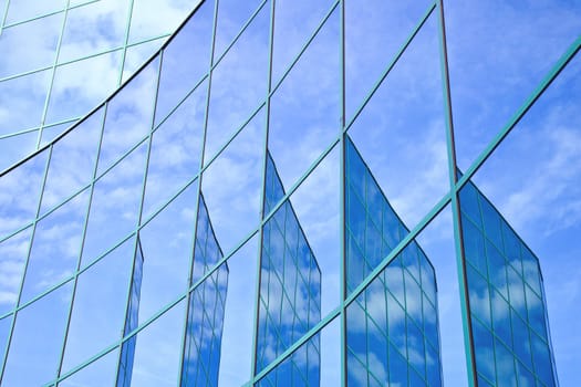 five reflections of facade with blue sky and clouds