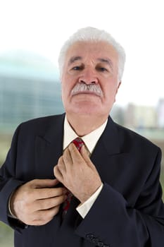 Experienced Businessman Adjusting His Tie