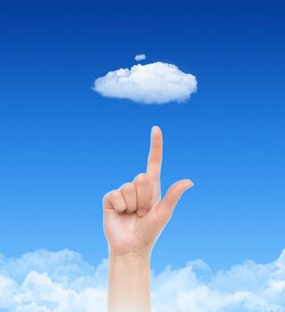 Woman hand point on cloud against blue sky with clouds. Concept image on cloud computing and eco theme.