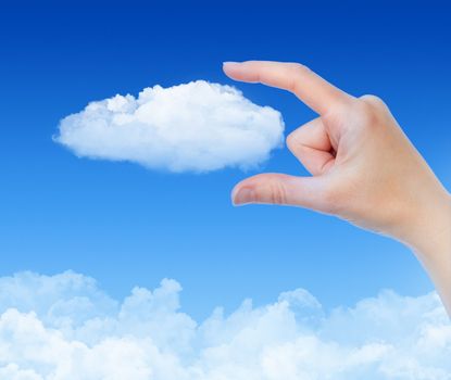 Woman hand measures the cloud against blue sky with clouds. Concept image on cloud computing and eco theme.