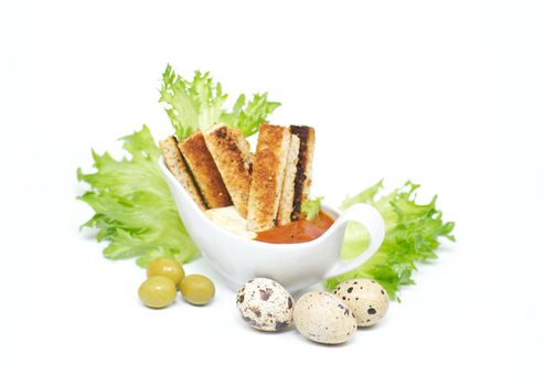 Snack from crackling bread with cheese sauce and a BBQ ketchup, leaves of salad and olives