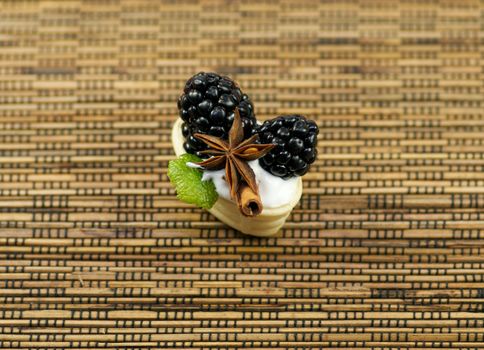 Small baskets from shortcake dough with whipped cream, a blackberry, cinnamon and anise