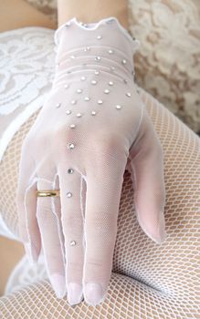 Close-up photo of the elegant hand in glove with wedding ring