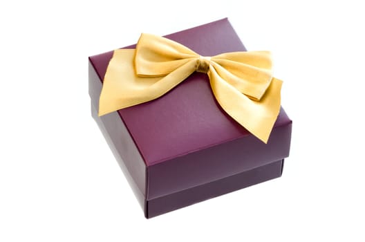 Gift box with a gold ribbon bow isolated on white background.