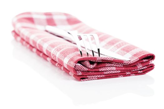 knife and fork on a red checkered towel on white background