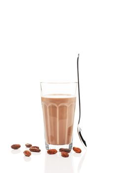 chocolate milk with chocolate beans and a standing spoon on white background