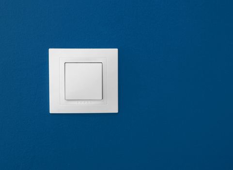Simple light switch on a blue wall 