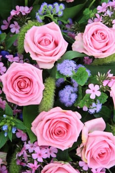 Floral arrangement with pink roses and purple and green decoration