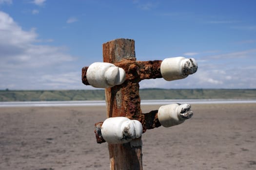 buried old wooden electricity pylons in the sand of Kuyal'nik Liman close up