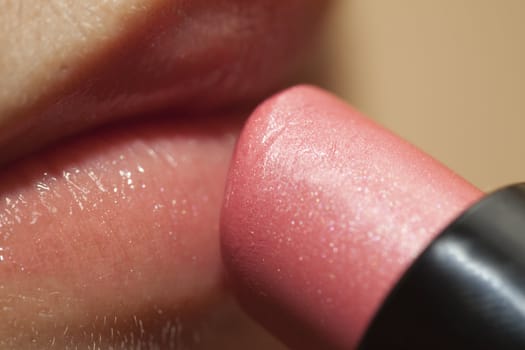 Close-up of a woman lips applying red lipstick.