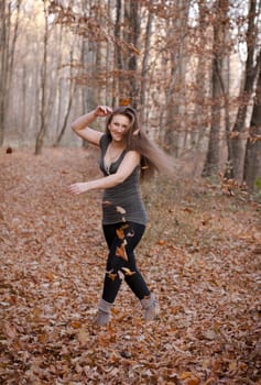 girl throws up in the autumn forest leaves
