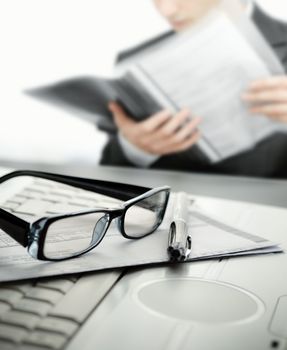 Businessman reading a contract with selective focus on glasses and pen
