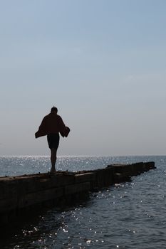 lonely boy go over the pier into the sea