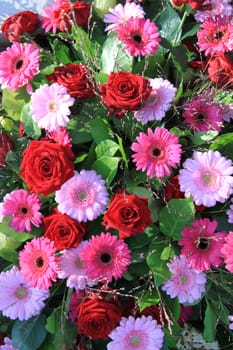 Flower arrangemnt with red roses and pink gerberas in the sun