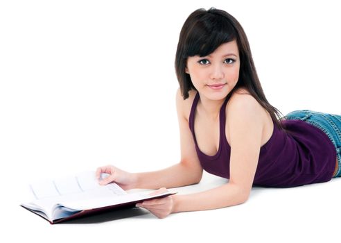 Portrait of a cute student lying on the floor with her book over white background